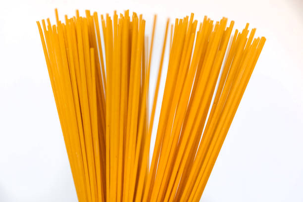 male hand holds spaghetti on a white background. close up