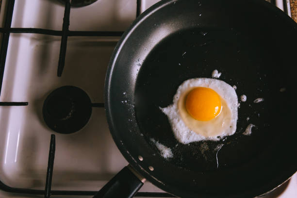istock Fried egg in a frying pan on a white stove. 1814858494