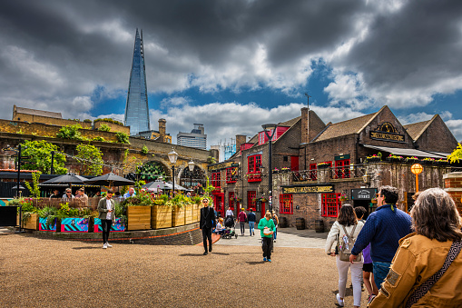 London, United Kingdom - May 30, 2023: Many people walking in a pedestrian zone with The Shard Building in background