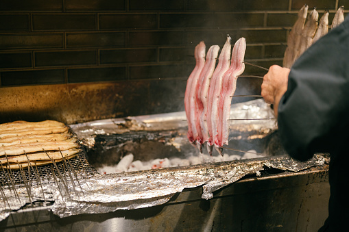 Chef Traditional grilling and puring sauce on Unagi no Kabayaki freshwater eel one popular unagi dish in Osaka Japan