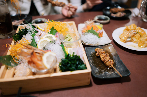 Asian taiwanese / thai happy meal eating Sushi Set sashimi and sushi rolls in luxury japanese restaurant