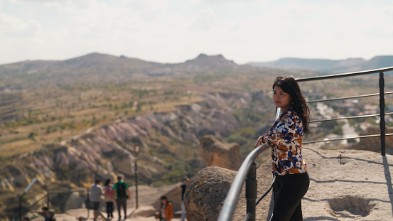 A portrait of a multiracial female tourist looking at view from high above in Cappadocia Türkiye Turkey