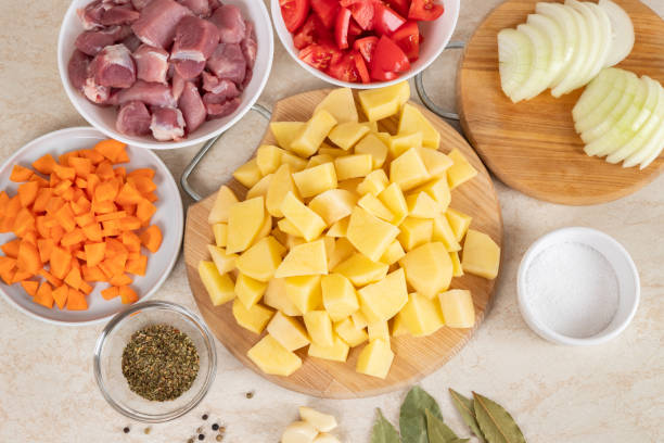 istock Prepared ingredients for cooking stewed potatoes with meat in multi cooker in kitchen on a table. Cooking stewed potatoe with meat in multicooker. Top view. 1814878177