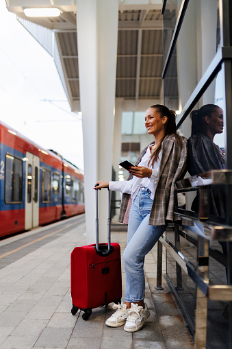 Female passenger at train station. Travel and active lifestyle concept. Travel by train