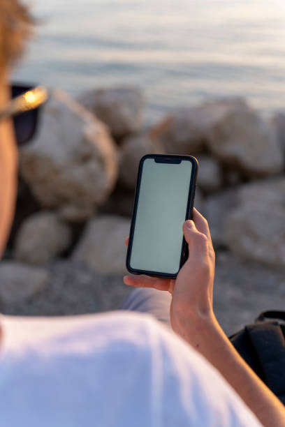 istock Mock Up Smartphone in man's hand, background a outdoor. White screen. 1814892193