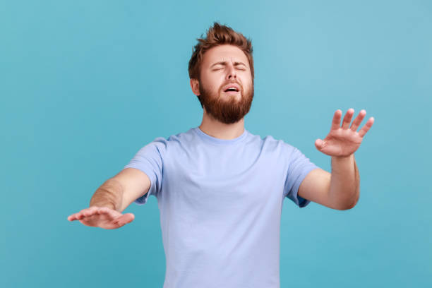 istock Man standing with closed eyes and try to touching something or find, posing with outstretching hands 1814900645