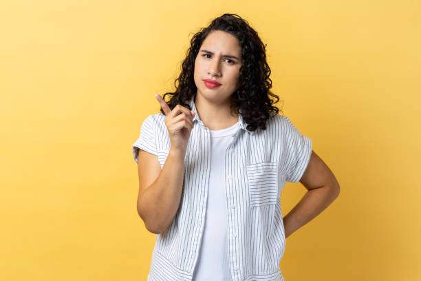 istock Woman pointing finger at camera and looking with dissatisfied suspicious expression 1814908009