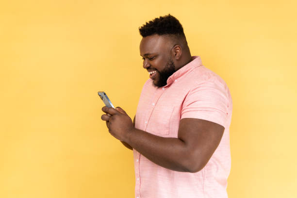 istock Side view of bearded happy man using mobile phone with happy expression, addicted to smartphone. 1814909742