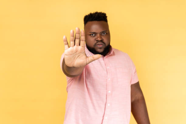 istock Man standing with disgust expression, frowning showing stop gesture with hand. 1814909747