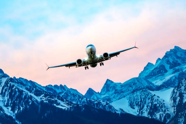 istock passenger plane flies over the mountains. air transport industry 1814913146