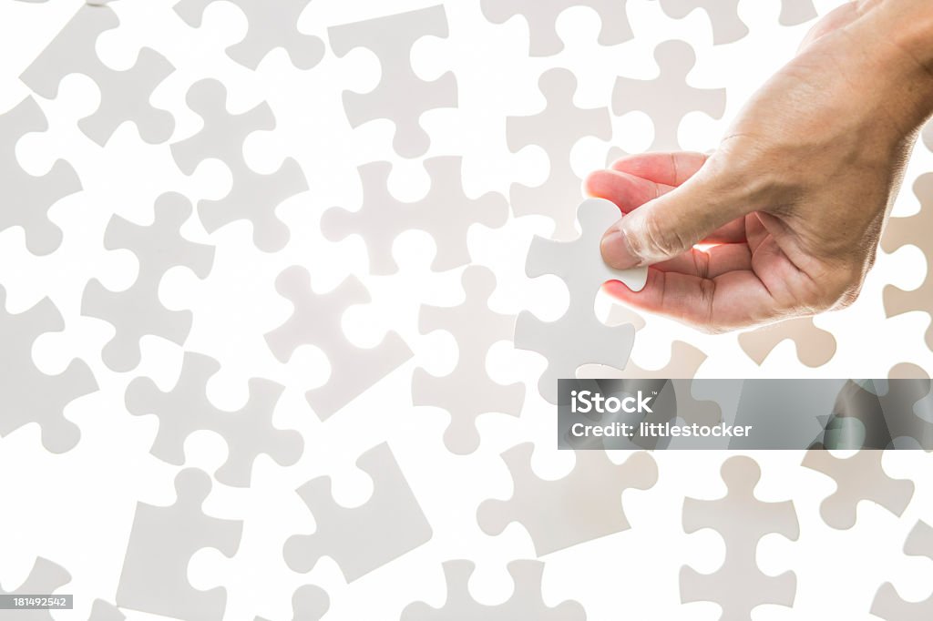 Man mano che tiene il pezzo del puzzle jigsaw - Foto stock royalty-free di Abilità