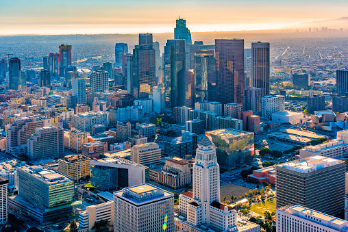 The skyline of Los Angeles, California in the late afternoon backlit by the soon to be setting sun, shot via helicopter from an altitude of about 1000 feet over the city.