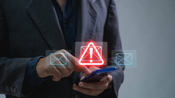 istock A businessman using a smartphone to receive email warning alerts about spam, junk and trash mail, hacker and virus. Concepts of network security 1814946673