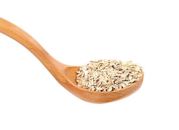 istock Oatmeal flakes into wooden spoon. 181495023