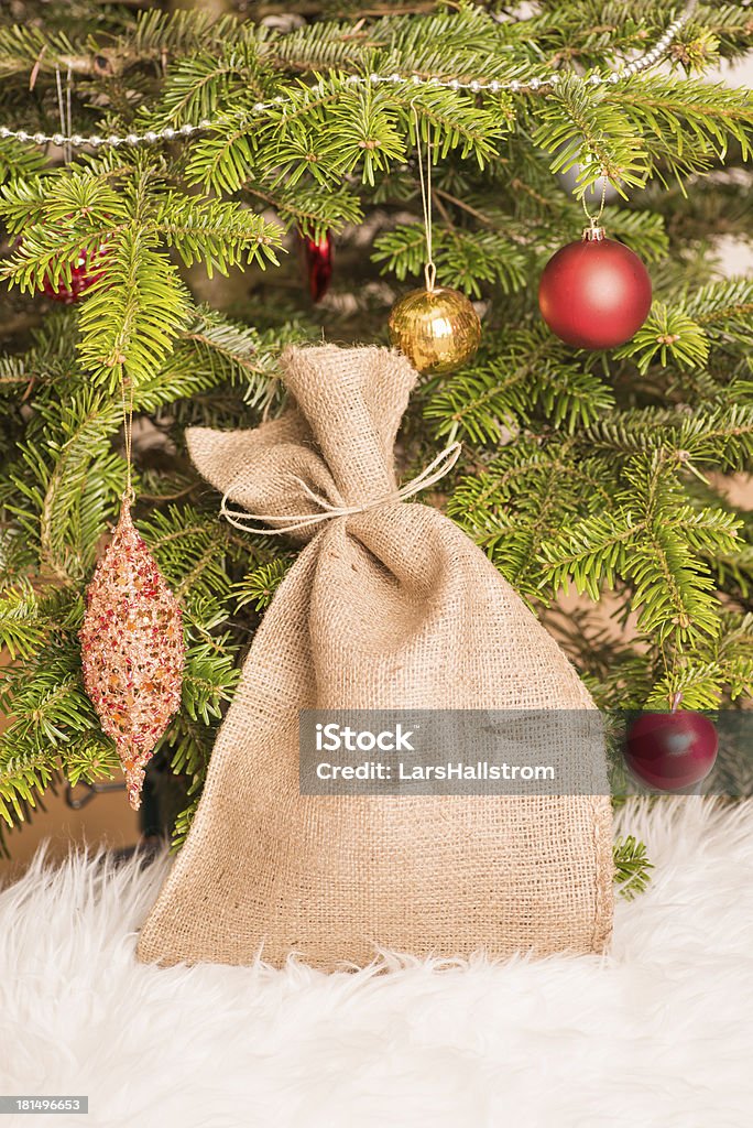 Árvore de Natal e tecido de saco repleto de presentes - Foto de stock de Tecido de Saco royalty-free