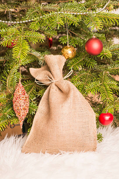 Árvore de Natal e tecido de saco repleto de presentes - foto de acervo