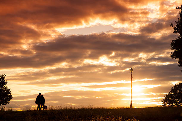 istock Couple walking into the golden overcast sunset silhouette 181496657