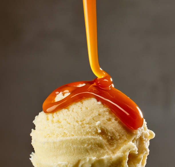 istock caramel sauce flowing on vanilla ice cream 1814968204
