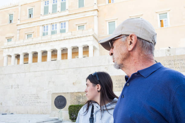 Grandfather and her granddaughter looking the Greek Parliament in Syntagma square. stock photo