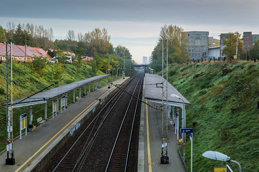 Katowice Brynow, Poland. October 24, 2023. A small railway station surrounded by a slope covered with greenery. The city in the distance.
