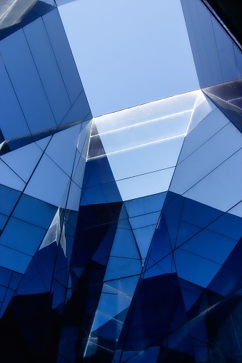 An architectural structure featuring a contemporary design, with blue glass panels on the facade