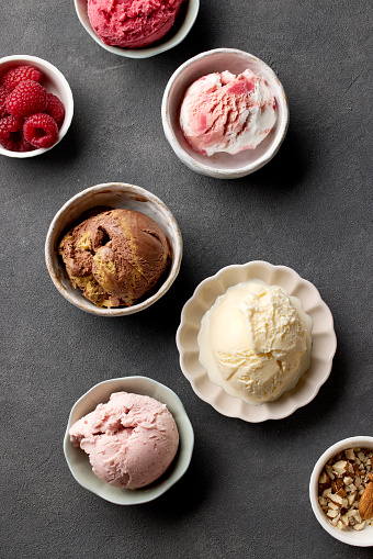 bowls of various ice creams on grey table, top view