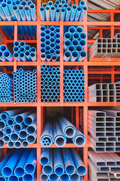 istock Various sizes of many blue PVC water pipes with carbon steel rectangular and square tubes on storage shelf of building supply store in vertical frame 1815009763