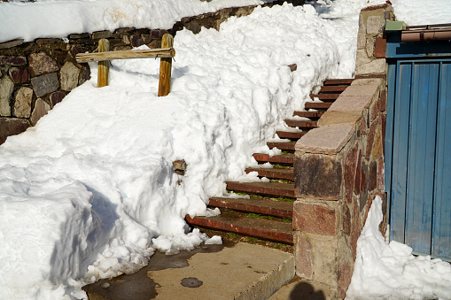 Under the light of a charming winter day, the stairs are adorned in white with snow, offering a serene and scenic view.