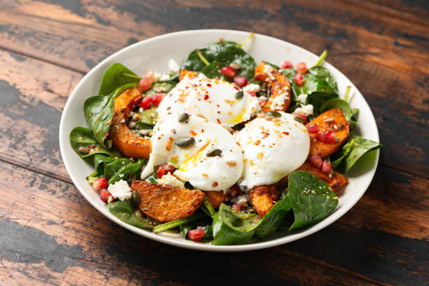 istock Roasted butternut squash salad served with poached eggs, spinach, nuts and pomegranate seeds 1815019836