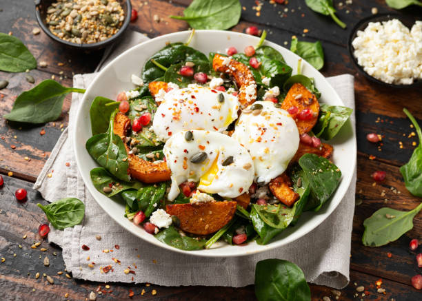 istock Roasted butternut squash salad served with poached eggs, spinach, nuts and pomegranate seeds 1815019974