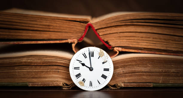 istock Old book and antique clock face, storytelling background 1815020899