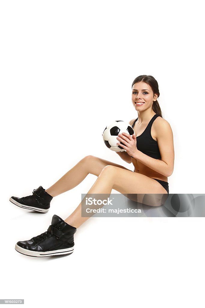 Sexy dziewczyna siedzi na Piłka nożna na białym tle - Zbiór zdjęć royalty-free (Aktywny tryb życia)