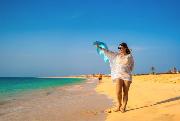 istock Beautiful woman walking on beach 1815046122