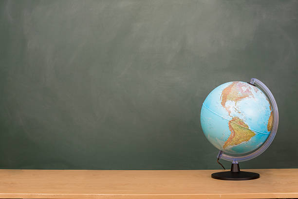 Back To School Globe of the world is on a desk with a copy space on the blackboard. desktop globe stock pictures, royalty-free photos & images