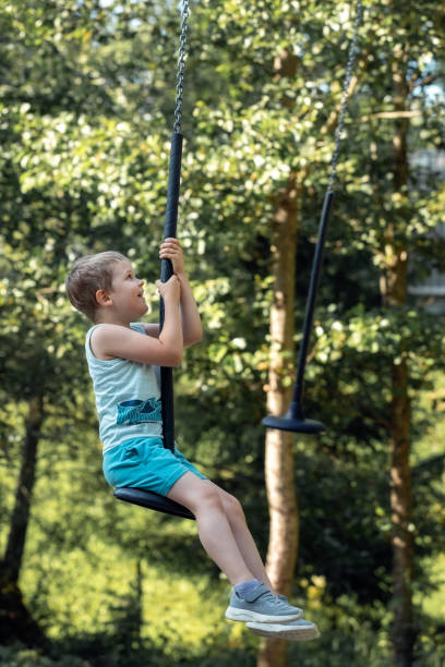 istock A summer forest walking trail attraction and a happy child spinning high 1815059615
