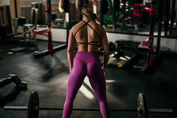 istock Woman in gym lifting heavy weights. 1815063977