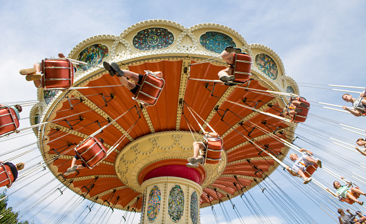 people riding a classic carousel on a sunny summer day in Sochi, Krasnodar Territory