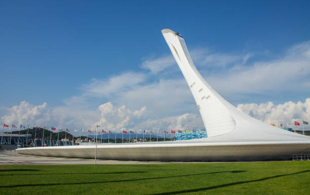 das denkmal der olympischen flamme im olympischen dorf an einem sonnigen sommertag. - olympic torch stock-fotos und bilder