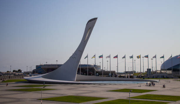 das denkmal der olympischen flamme im olympischen dorf an einem sonnigen sommertag. - olympic torch stock-fotos und bilder