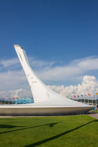 монумент «олимпийский огонь» в олимпийской деревне в солнечный летний день. - olympic torch стоковые фото и изображения