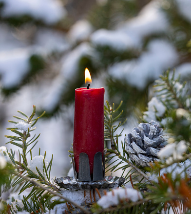 First Advent. Christmas background with snow,candle and fir tree.