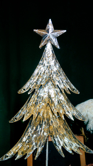 Close-up view, metal Christmas tree figurine with top star, decorations, fake fir tree figurine.