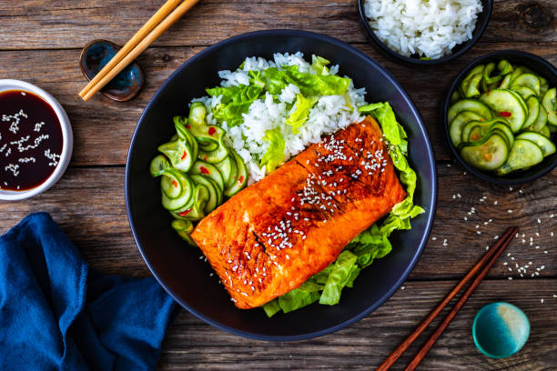 istock Seared teriyaki salmon steak with black and white rice on wooden table 1815102765