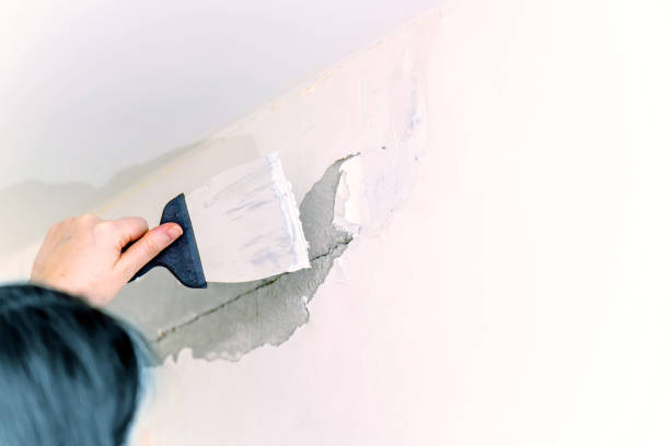 istock A worker repairs the fallen plaster with a spatula and putty 1815105928