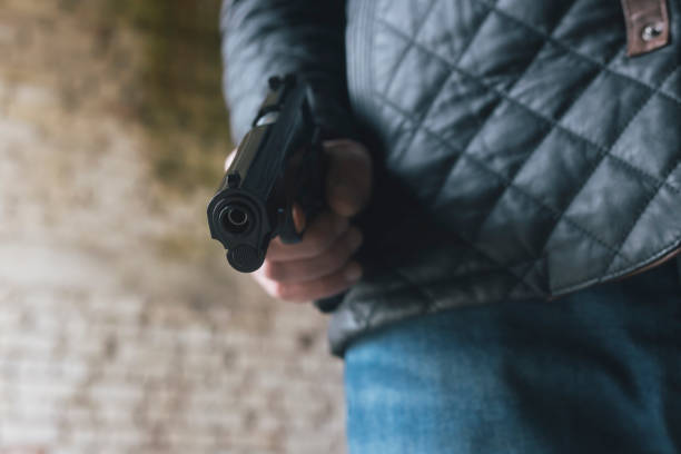 istock Man with gun at spooky abandoned dark building 1815106505