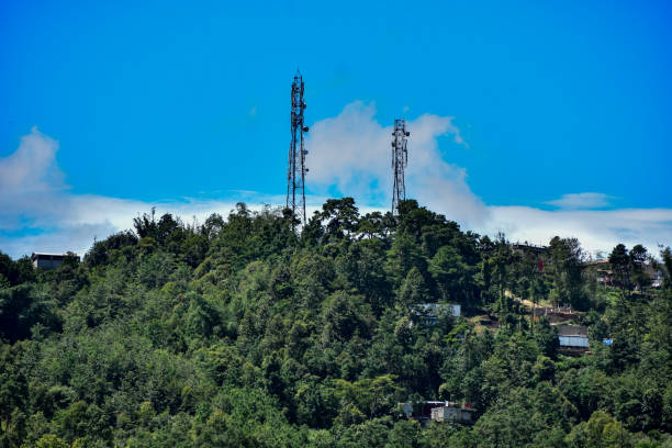istock Mobile towers over a hill with small houses . 1815106650