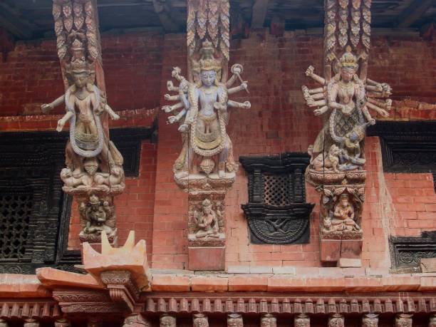 Carved, wooden struts on a temple at Durbar Square Kathmandu. The Mani Keshar Chauk temple on the Durbar Square Patan courtyard is dedicated to Lord Vishnu. On the outside the temple is, among other things beautifully decorated  with 3 wooden struts, each carved with multi-armed, tantric, Hindu deities. An absolute amazing craftsmanship patan durbar square stock pictures, royalty-free photos & images