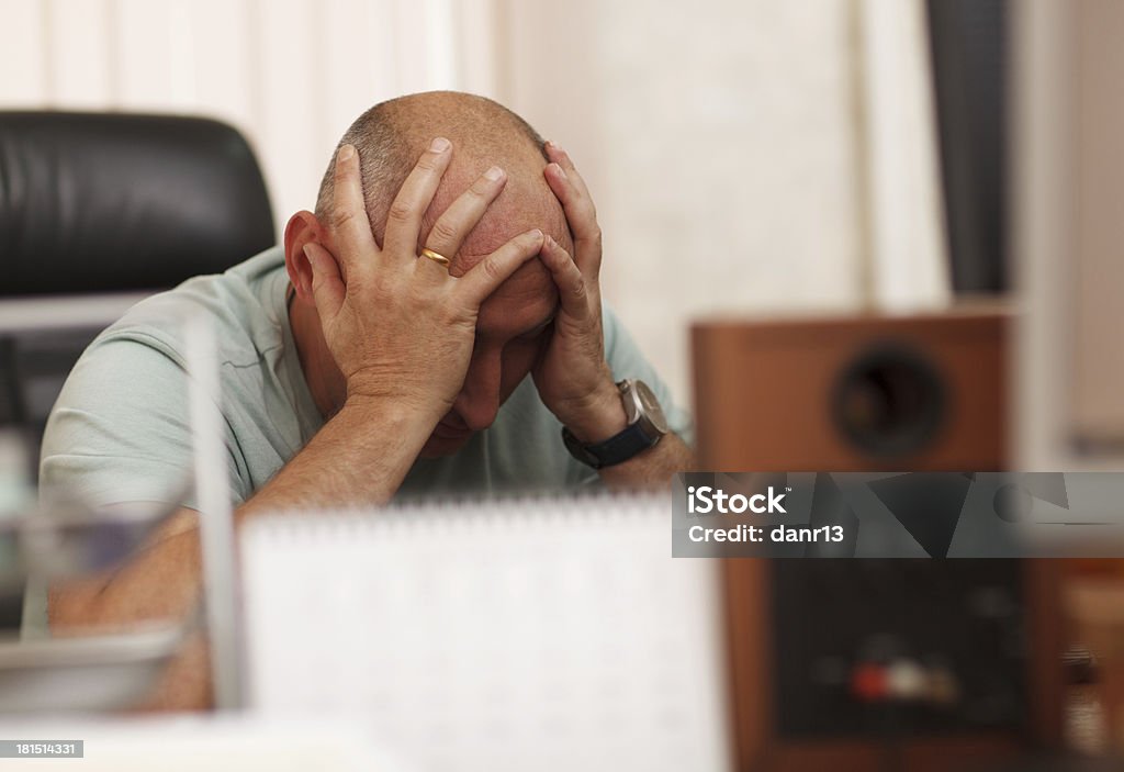 Problems at work or headache Middle-aged businessman in the office thinking about business problems Adult Stock Photo