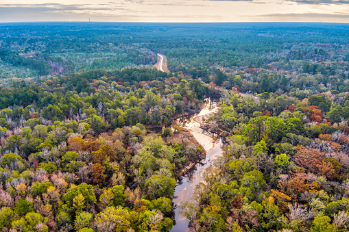 Aerial view of a Creek leading to a road in Texas during Autumn