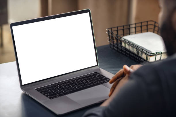 istock Man using laptop with blank screen sitting at the desk 1815148883